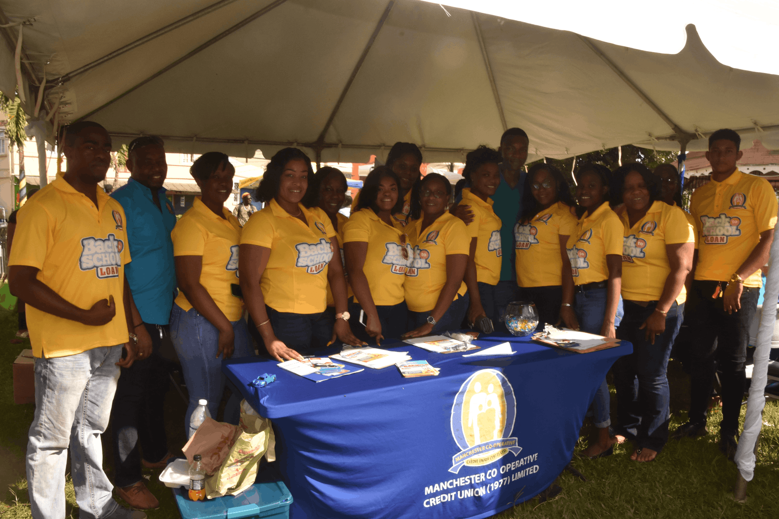 The MCCU team in Back to School Loan shirts gathered behind their booth at the extravaganza.