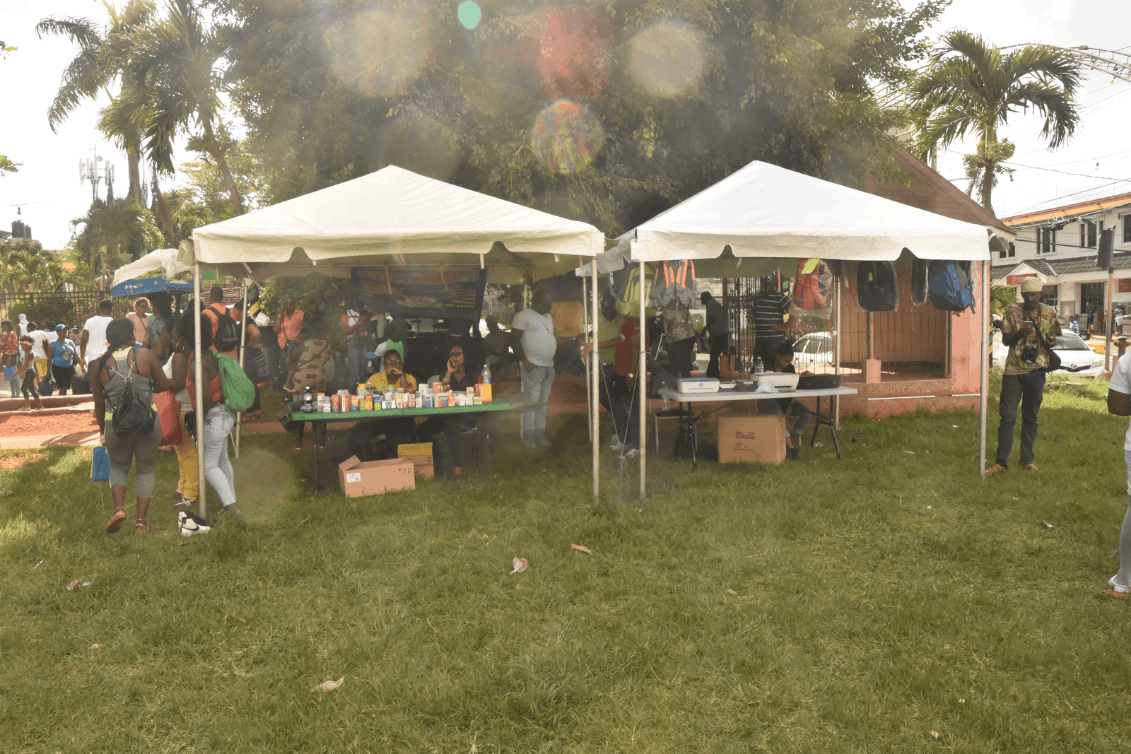 Tents set up on the grass at the Back to School Extravaganza with patrons visiting the booths.